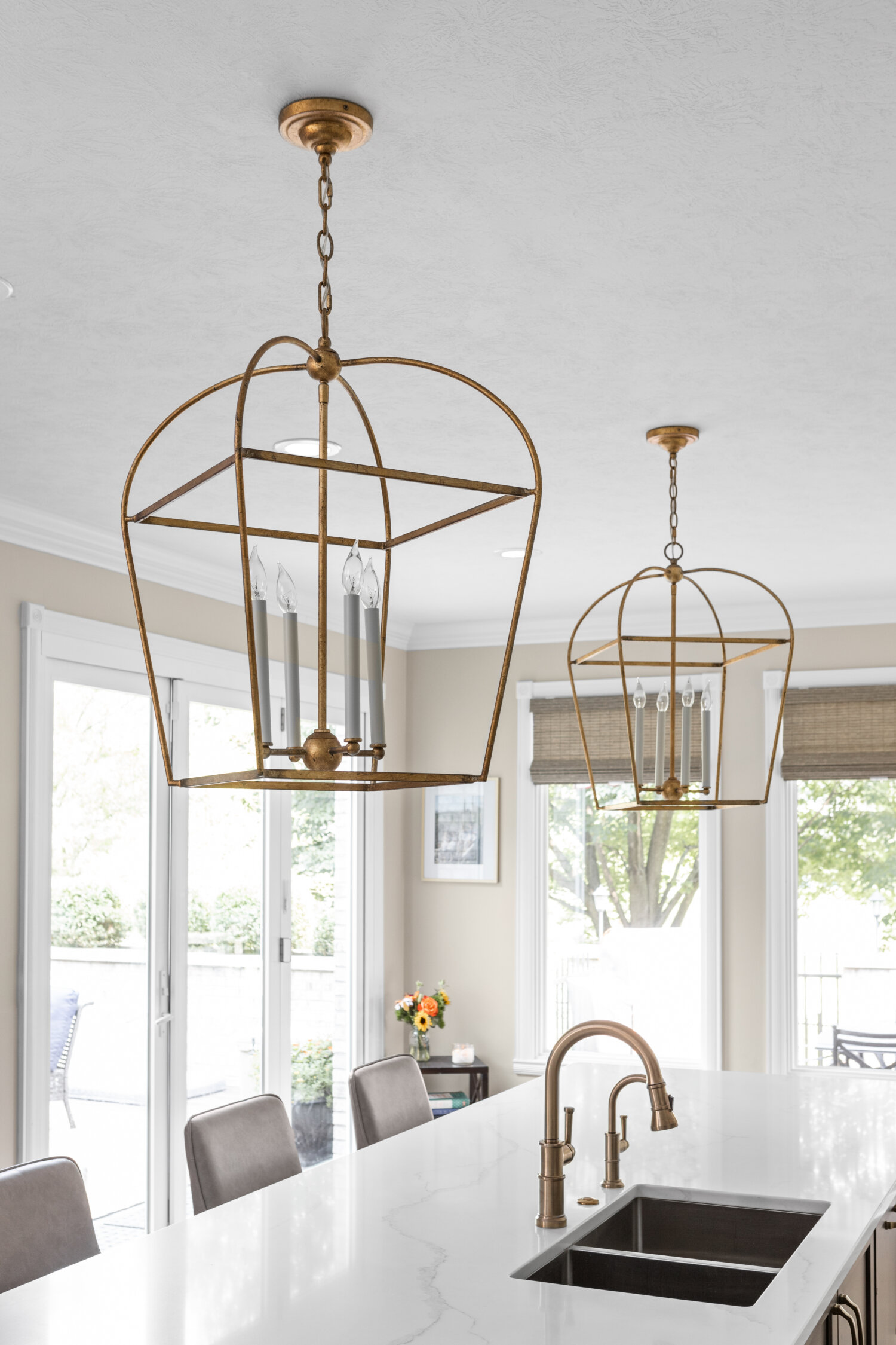 Two brushed brass lantern style pendant lights for above a kitchen island.