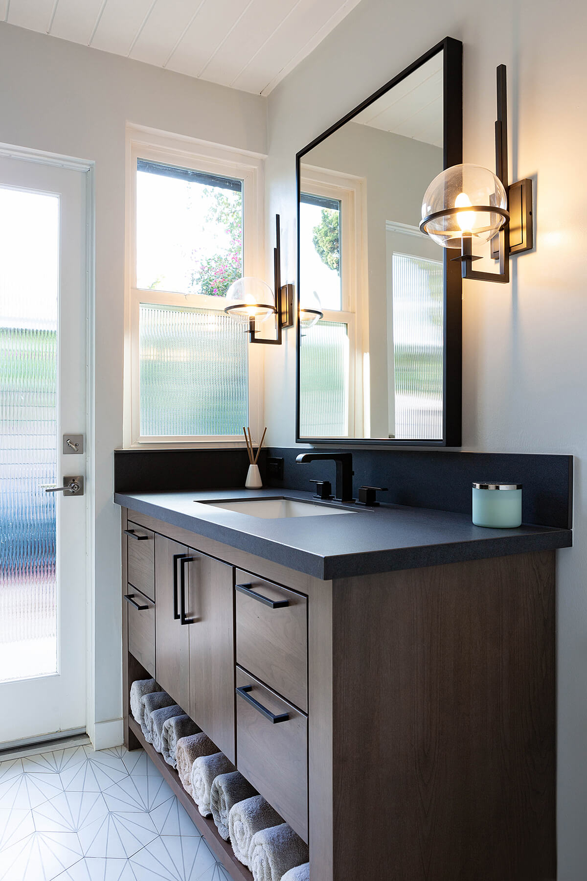 A sleek, modern furniture style vanity with a dark stained color from Dura Supreme Cabinetry.